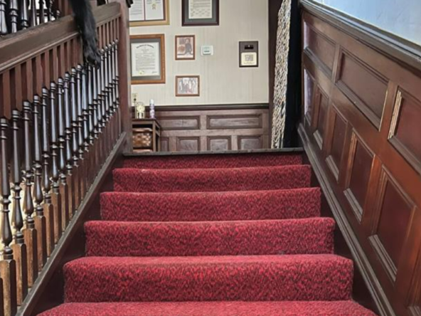 Plains B&B carpeted stairs plaques on the wall